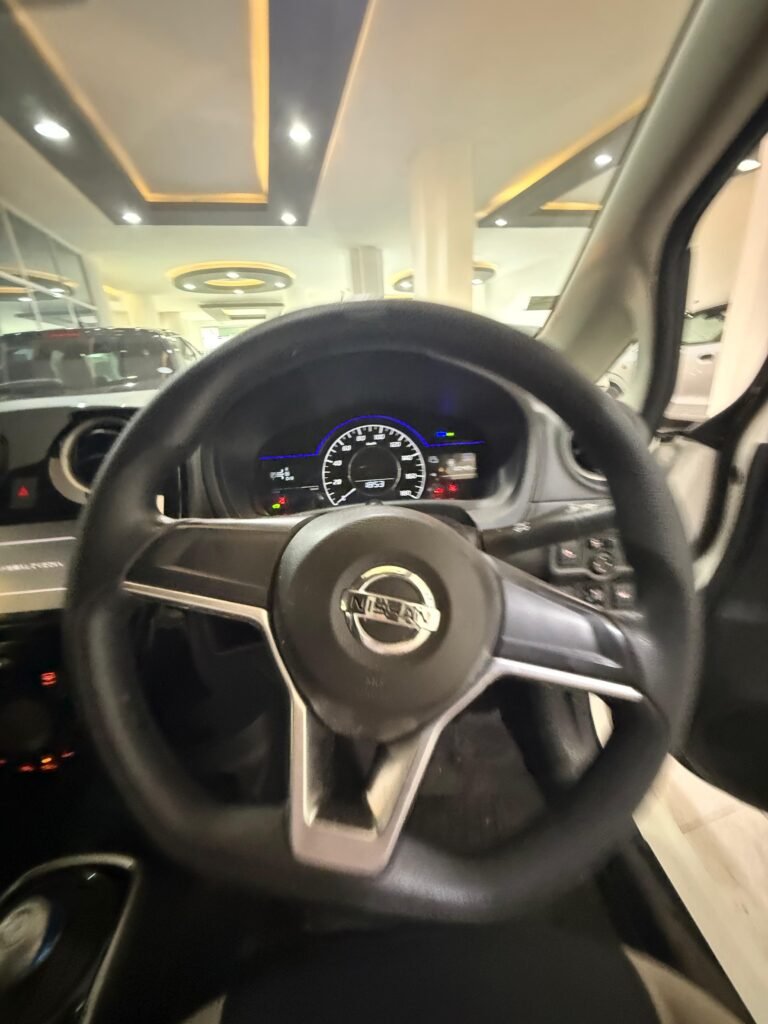 Futuristic cockpit of the 2019 Nissan Note E-Power showing the electronic gear shifter, push-start ignition panel, and high-contrast instrument display cluster.