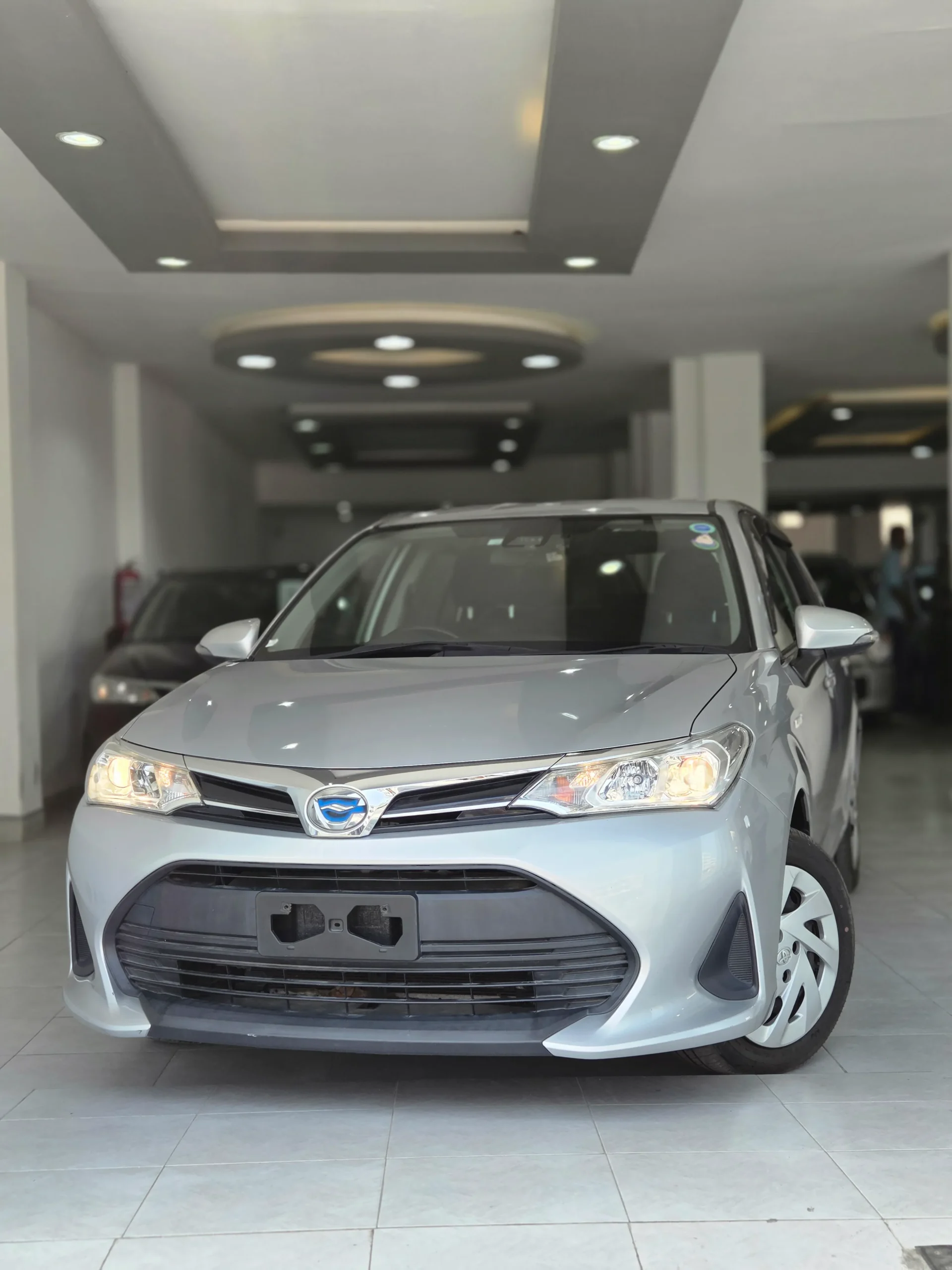 Silver Toyota Corolla Fielder Hybrid 2018 second-facelift model with sharp headlights and modern grille at Mundiya International Kenya.