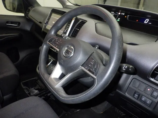 Spacious 7-seater cabin of the 2019 Nissan Serena featuring steering controls, digital dash, and dual power door switches.