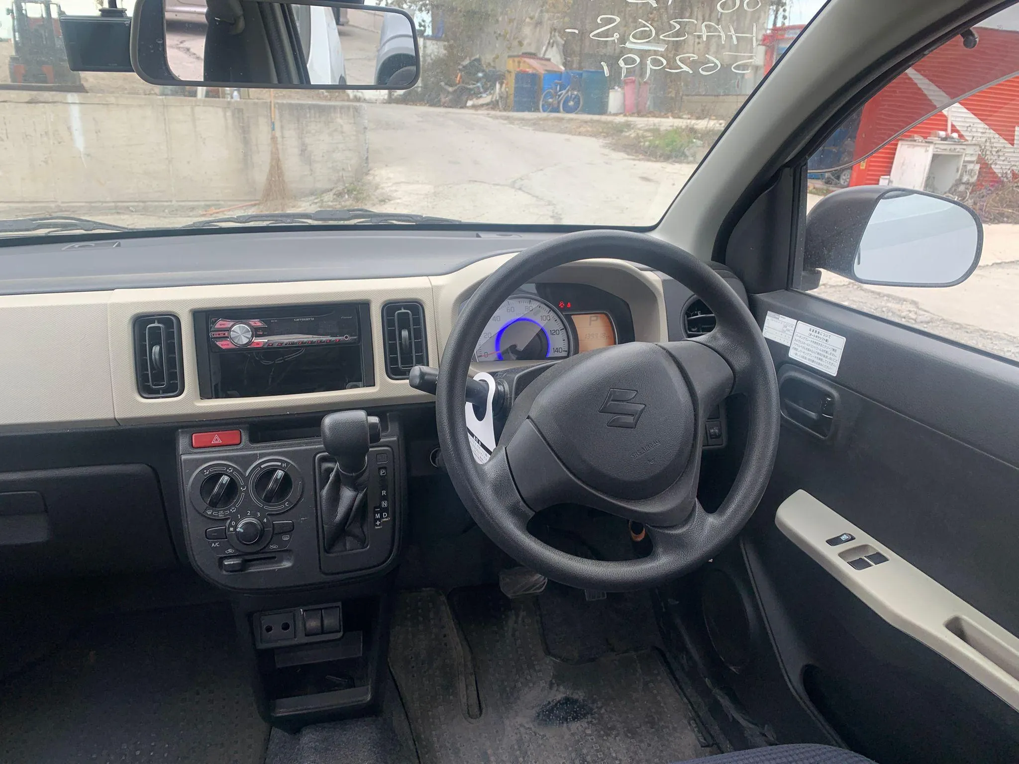 Practical cabin of the 2020 Suzuki Alto showcasing the semi-automatic AGS gear shifter and controls for the 4 powered windows.