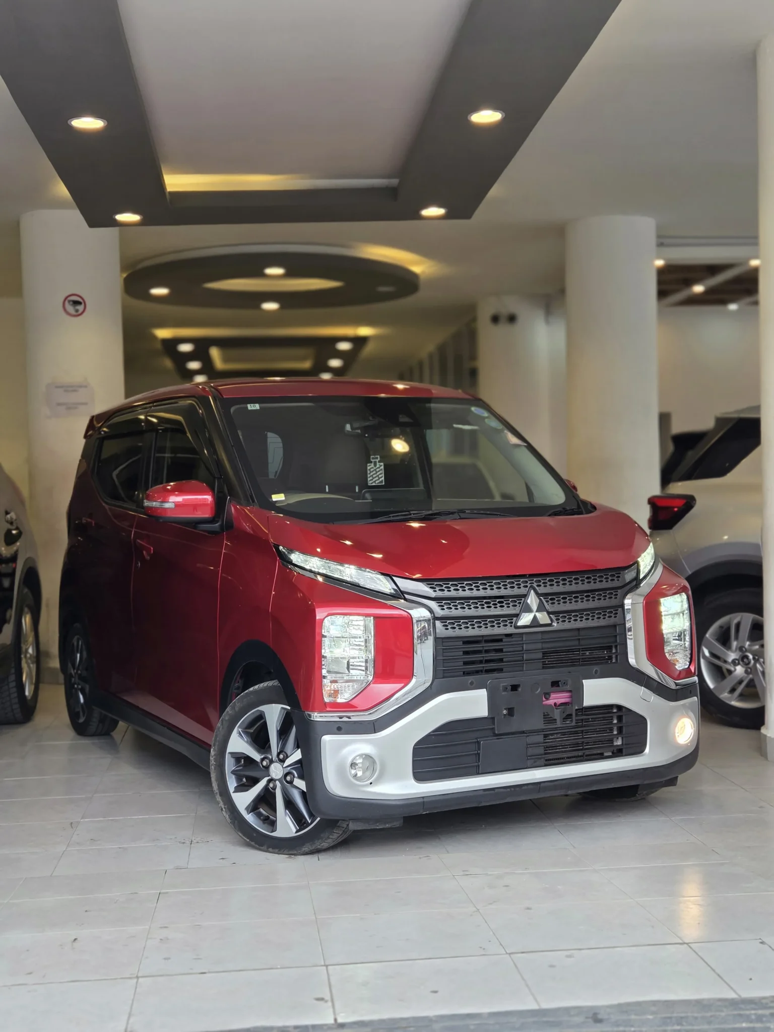 Vibrant red Mitsubishi eK X 2019 Hybrid G displaying its bold Dynamic Shield grille, Xenon LED headlights, and fog lights at Mundiya International Kenya.