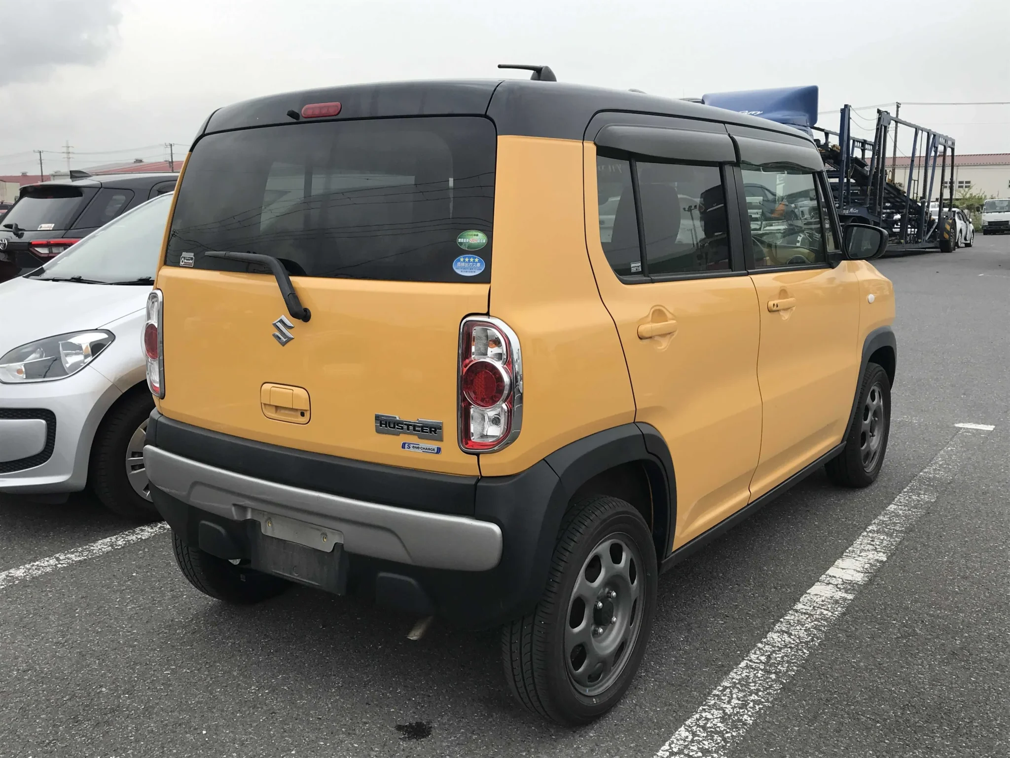 Playful two-tone Suzuki Hustler 2019 showcasing its flat vertical tailgate, factory alloy rims, water-resistant cargo deck, and S-Ene Charge hybrid emblem for sale in Nairobi.