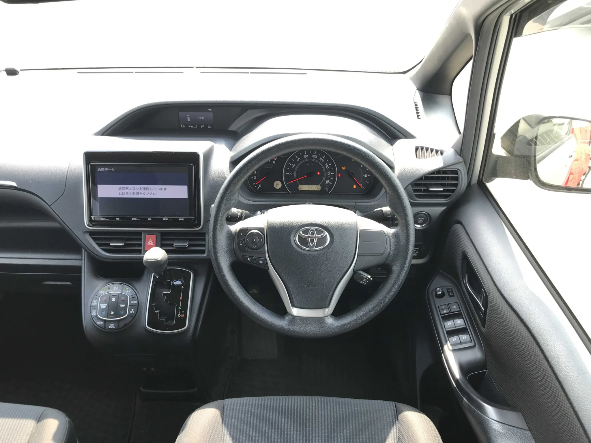 Spacious 8-seater interior cabin layout of the 2019 Toyota Noah X featuring a black dashboard, push start ignition button, cruise control levers, and automatic power door controls.